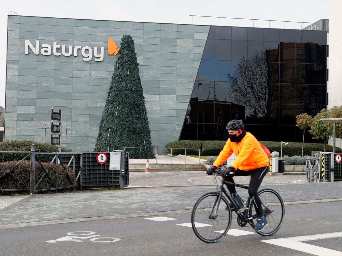 Foto: Un ciclista pasa ante la sede de la compañía energética Naturgy, en Madrid. (EFE)