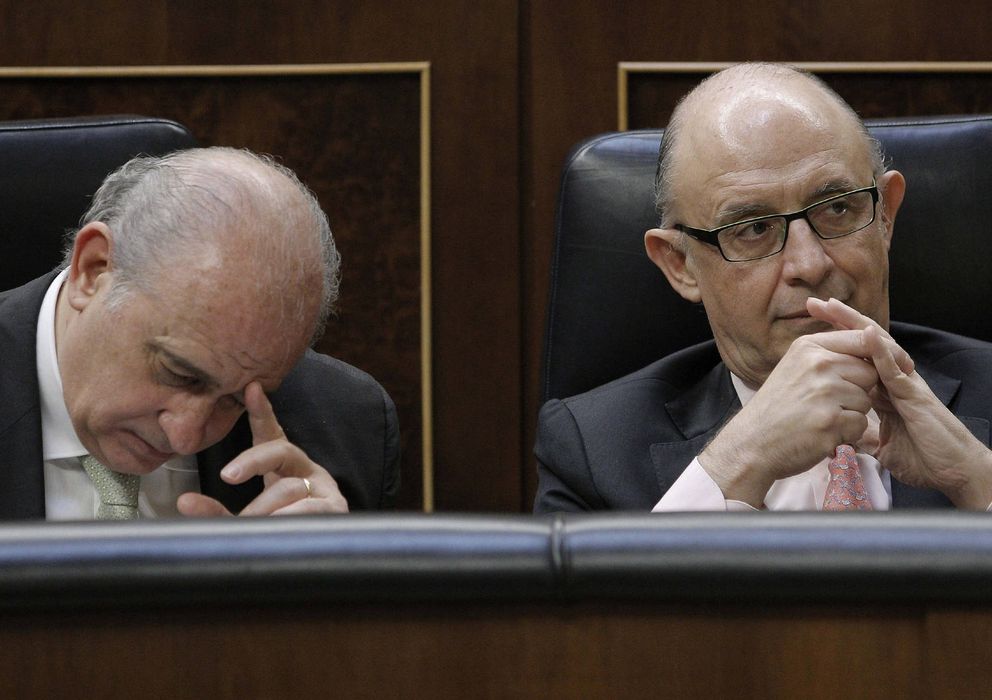 Foto: Los ministros de Interior y de Hacienda, en sus asientos en el Congreso (EFE)