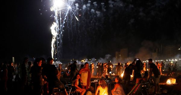 Foto: Numerosas personas disfrutan de la Noche de San Juan en la playa del mismo hombre de Alicante. (EFE)