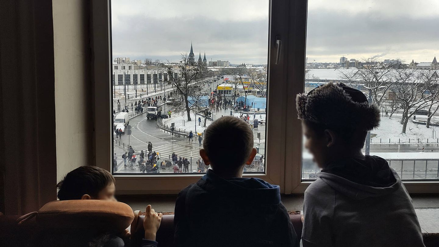 Niños observan desde la ventana de la segunda planta de la estación de Lviv. (L. Proto)