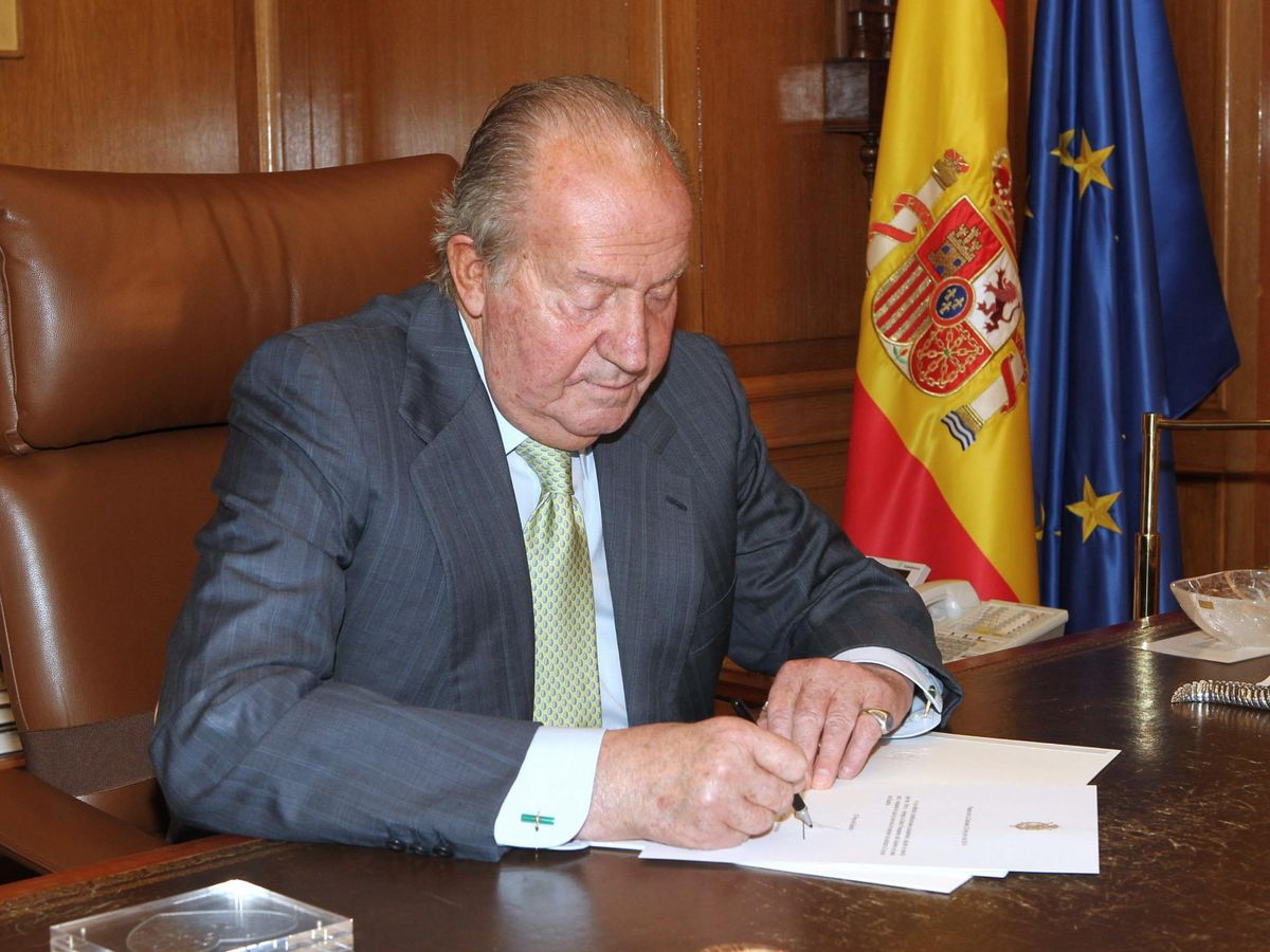 Foto: El rey Juan Carlos firmando el documento de su abdicación en 2014. (EFE)