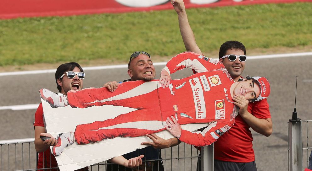 Unos aficionados sostienen una silueta en cartón de Fernando Alonso en el Circuit de Catalunya. (EFE)