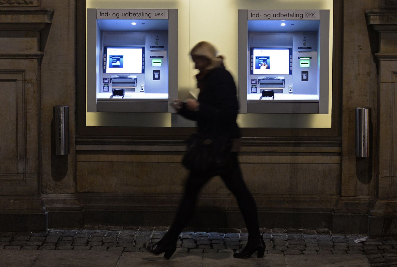 Una mujer pasa por delante de dos cajeros automáticos en Copenhague, Dinamarca, el 22 de enero de 2015 (Reuters)