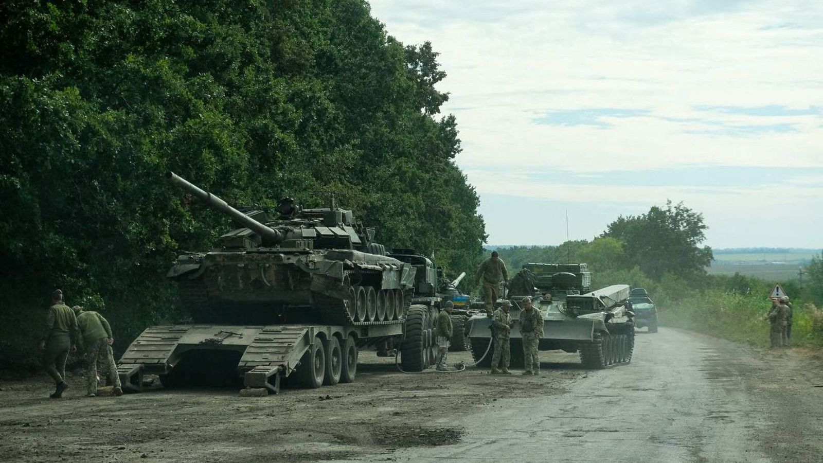Soldados ucranianos se preparan para remolcar un tanque ruso capturado en Járkov, durante la operación de contraofensiva de las últimas horas. (Reuters)
