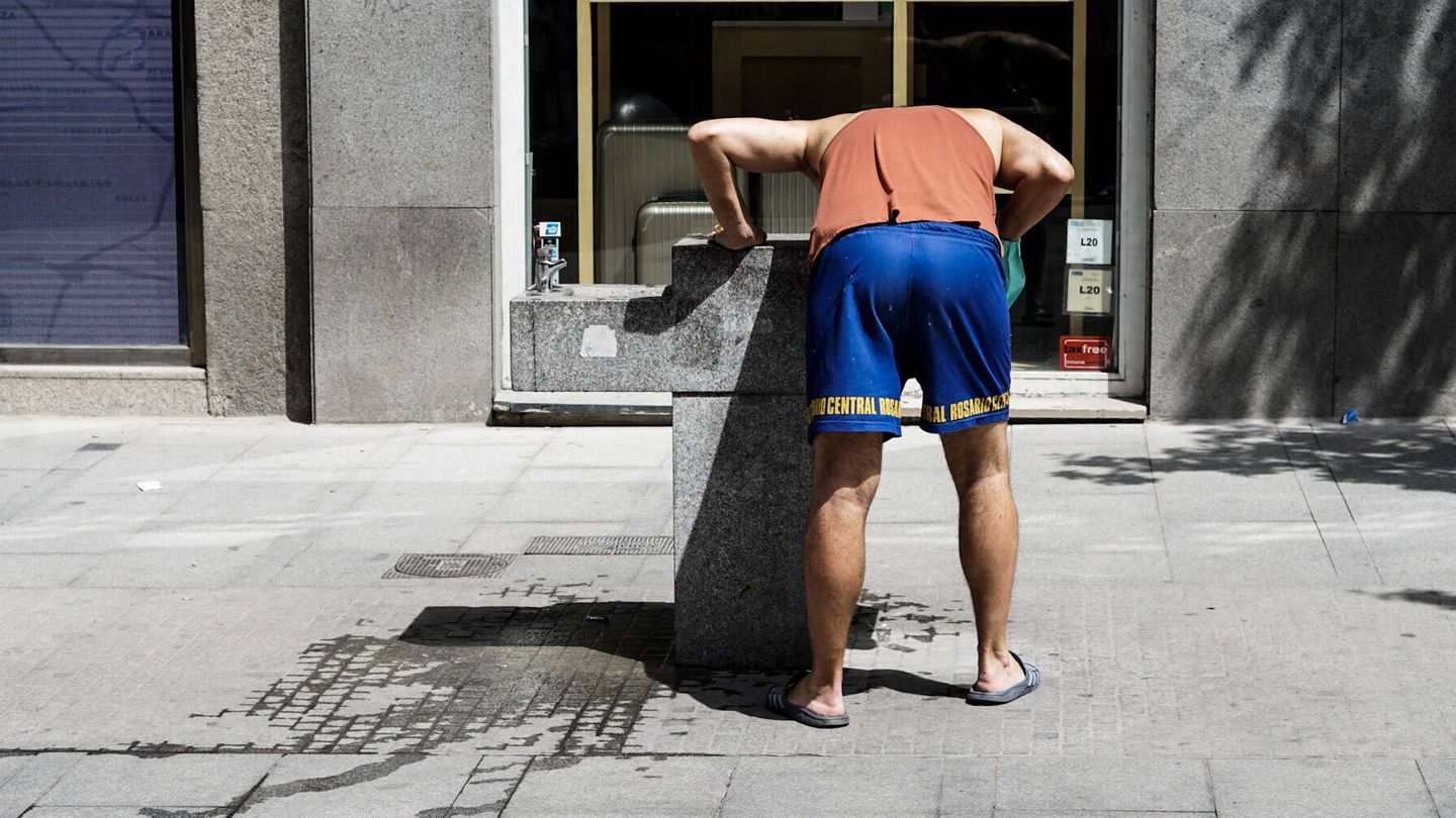Un hombre se refresca en una fuente en Madrid. (McLoughlin)