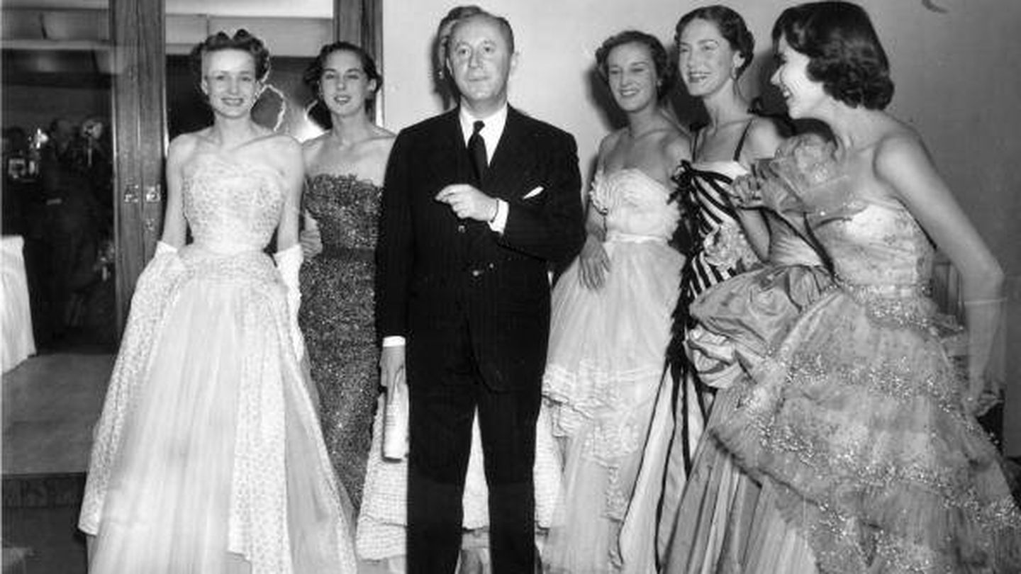 Christian Dior 1950, con varias modelos tras un desfile en un hotel de París.  (Getty)