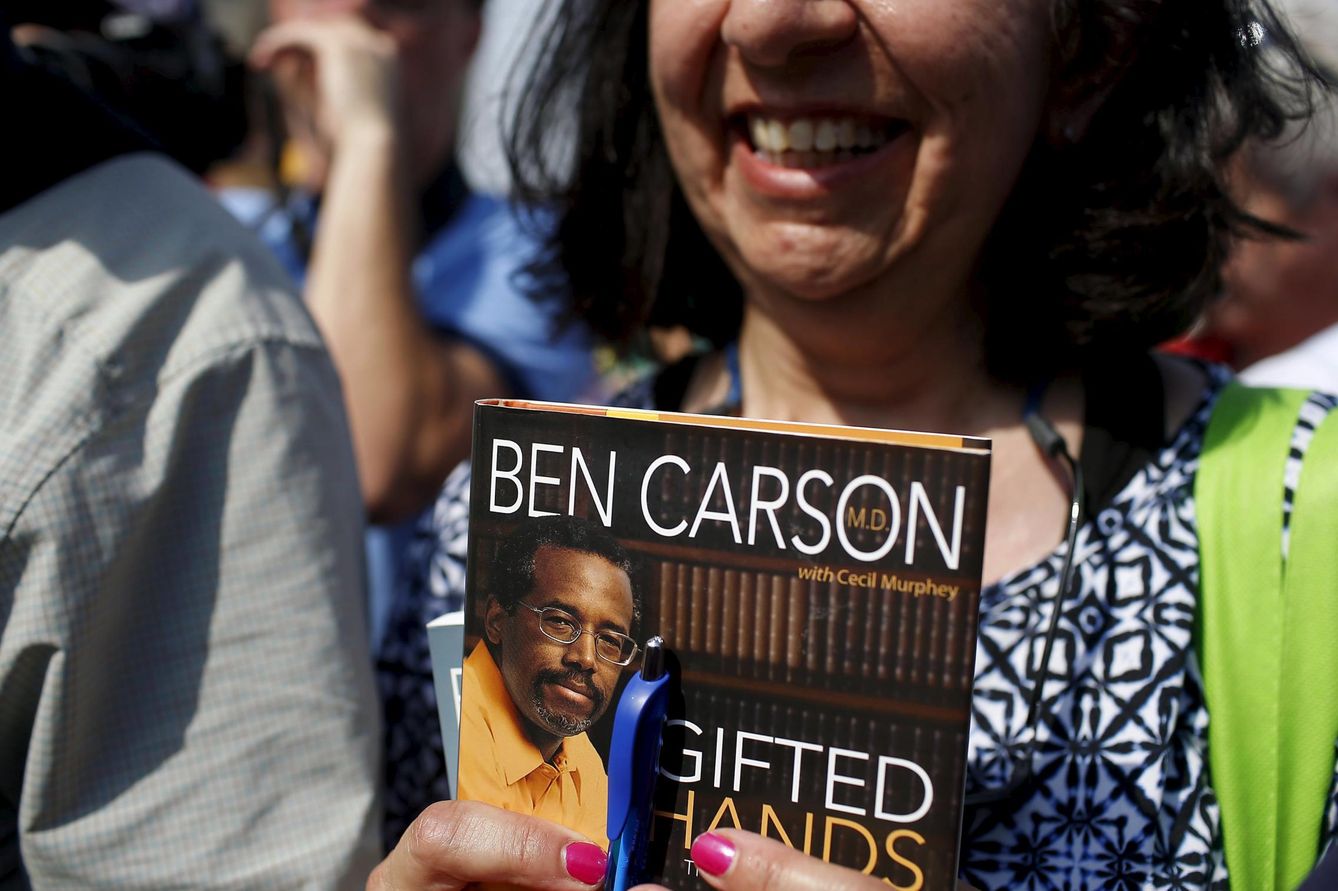 Una mujer espera a que Ben Carson le dedique uno de sus libros durante un mitin del candidato en Iowa (Reuters).