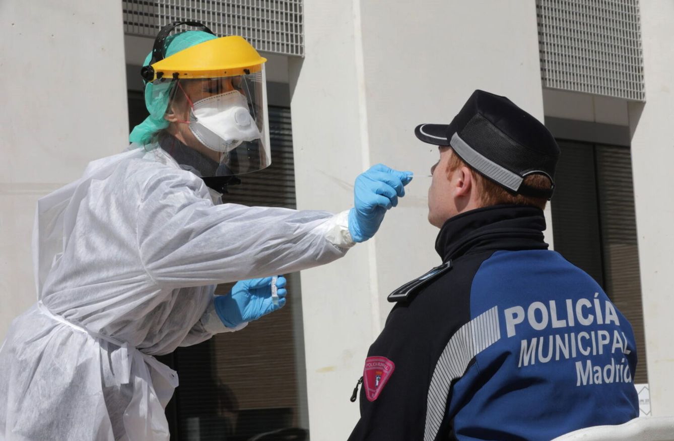 Una sanitaria realiza un test contra el coronavirus a un policía en Madrid. (EFE)
