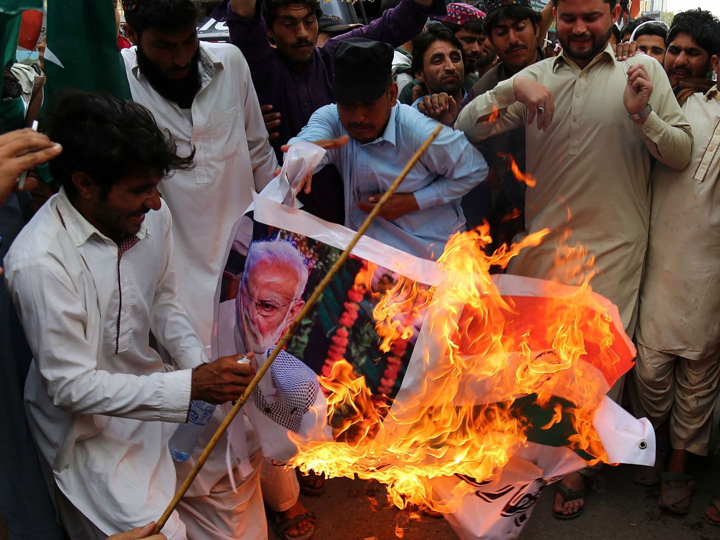 Refugiados afganos queman fotos de Narendra Modi durante una protesta contra India en Karachi, Pakistán. (EFE)