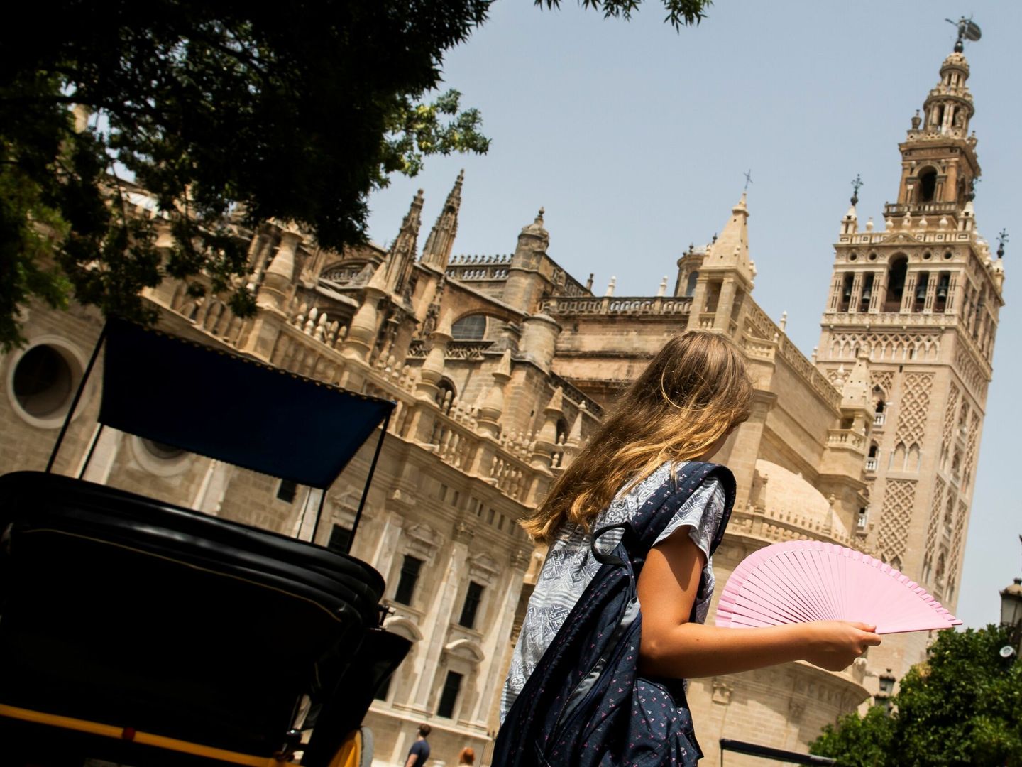 Una mujer pasa ante la catedral de Sevilla. (EFE)
