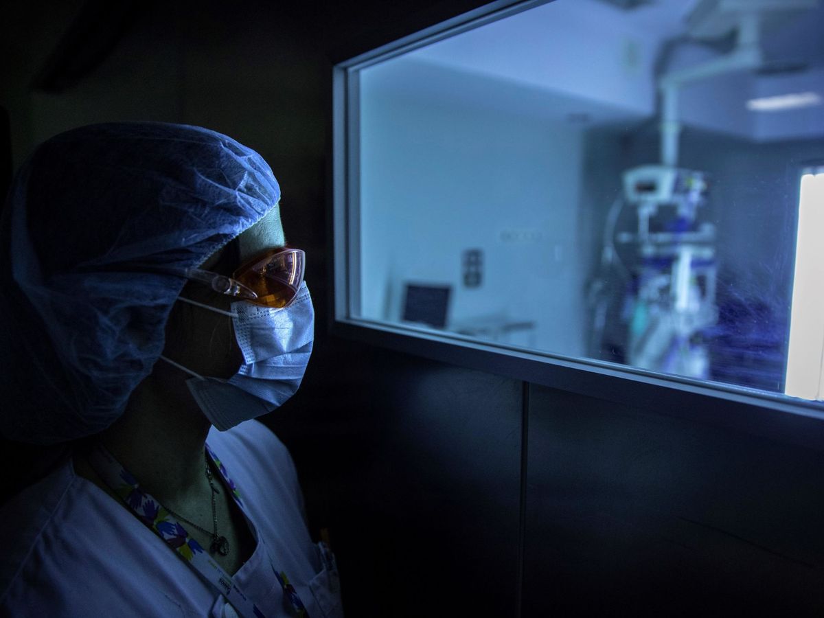 Foto: Una sanitaria observa el funcionamiento de un dispositivo de luz ultravioleta continuo (UV-C) móvil. (EFE)