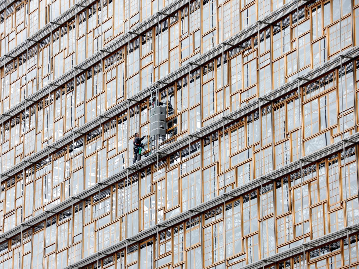 Dos trabajadores limpian los cristales del Consejo Europeo. (Reuters)
