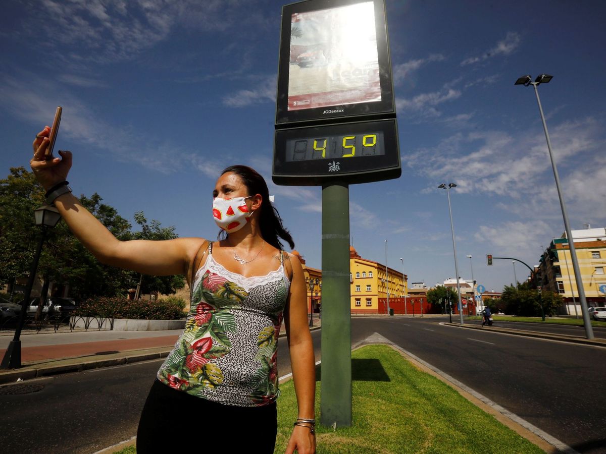 Foto: Una mujer se hace una foto junto a un termómetro que marca los 45 grados en las calles de Córdoba. Foto: EFE Salas