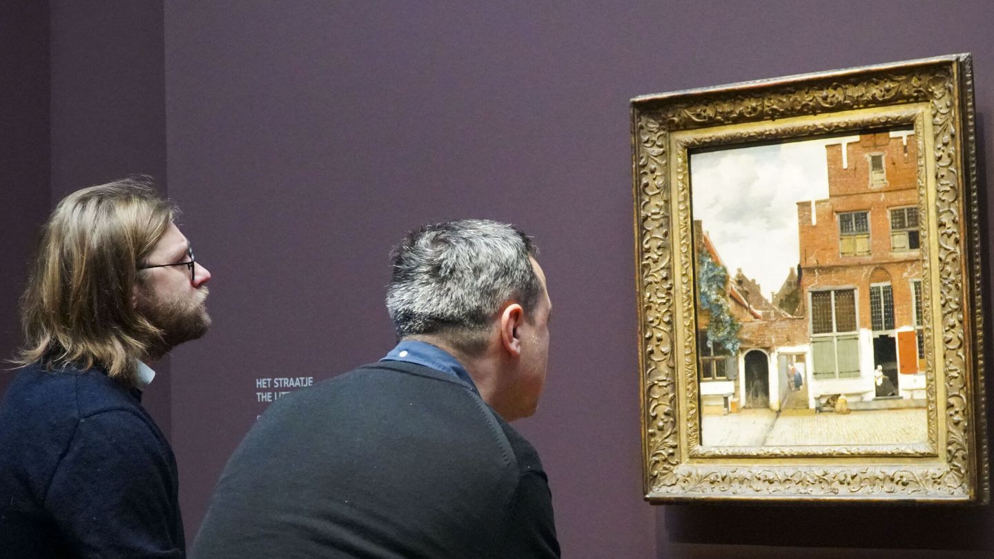 dos personas contemplan 'Vista de las casas en Delf', otro de los 28 cuadros de Vermeer que componen la retrospectiva del Rijksmuseum.EFE