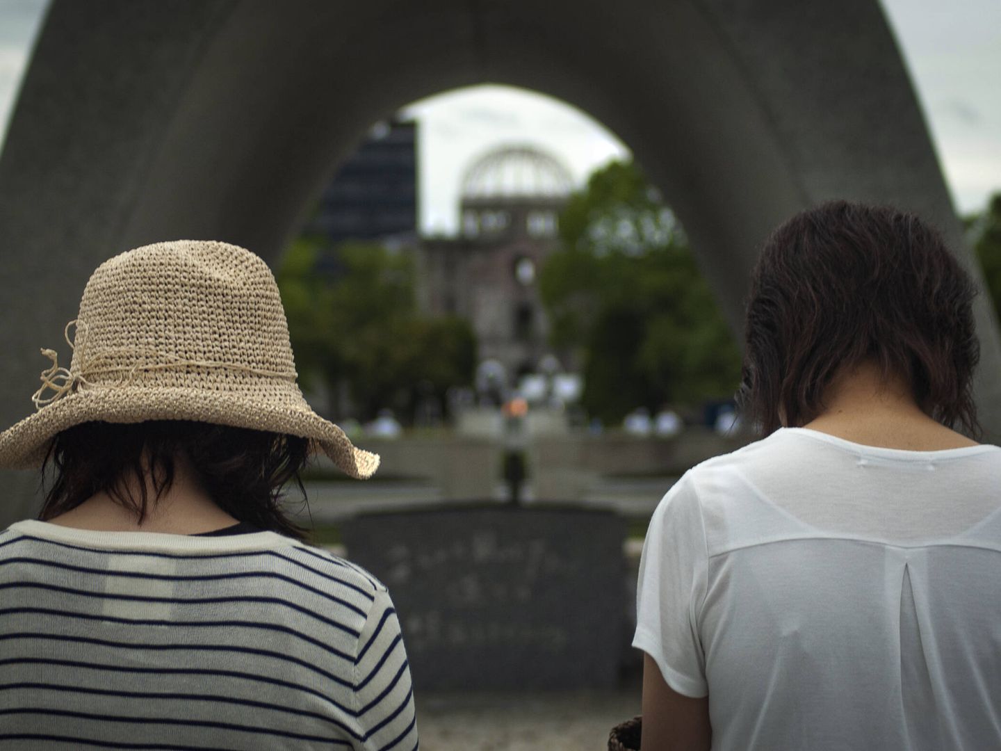 Dos jovenes, rezando ante el cenatofio de Hiroshima en memoria de las víctimas de la bomba atómica. TOÑI GUERRERO