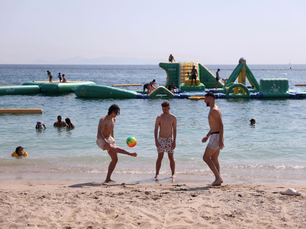 Foto: Unos jóvenes juegan en la playa. (Reuters/Louiza Vradi)