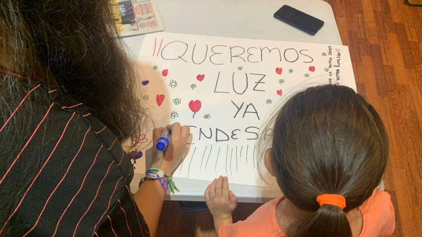Una madre y una hija pintan una pancarta para reclamar que Endesa garantice el suministro de luz. (M. J. G.)