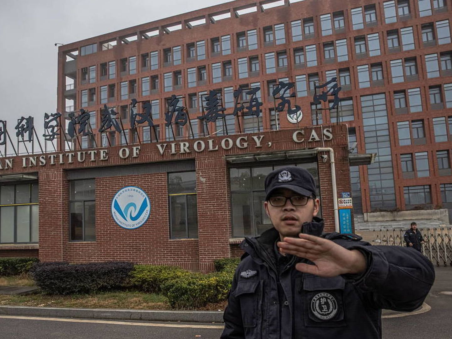 Un guarda de seguridad trata de impedir tomar fotos del Instituto de Virología de Wuhan. (EPA)
