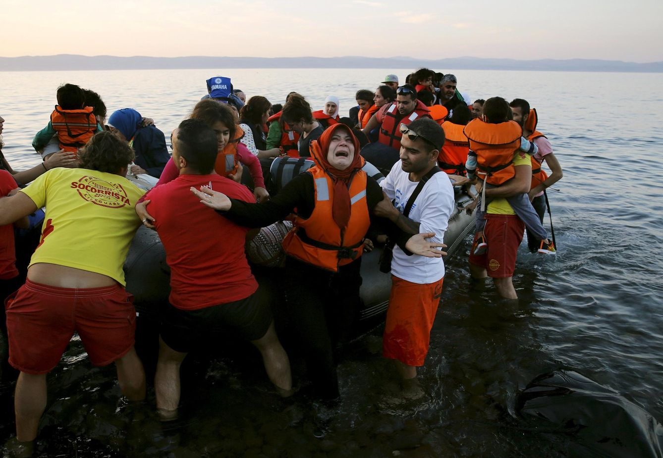 Una refugiada siria al llegar con su familia en una lancha neumática a la isla griega de Lesbos desde las costas de Turquía. (Reuters)