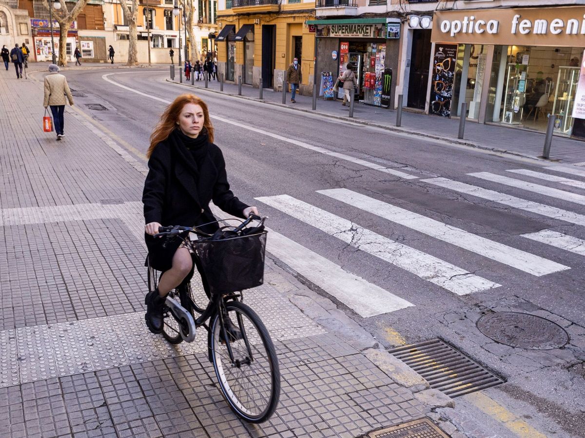 Foto: Una mujer monta en bicicleta por el centro de Palma de Mallorca. (EFE/Cati Cladera)