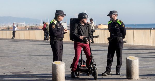 Foto: Agentes de la Guardia Urbana de Barcelona informan a un ciudadano, que circula con un patinete eléctrico, sobre la normativa de circulación que afecta a este tipo de patinetes. (EFE)
