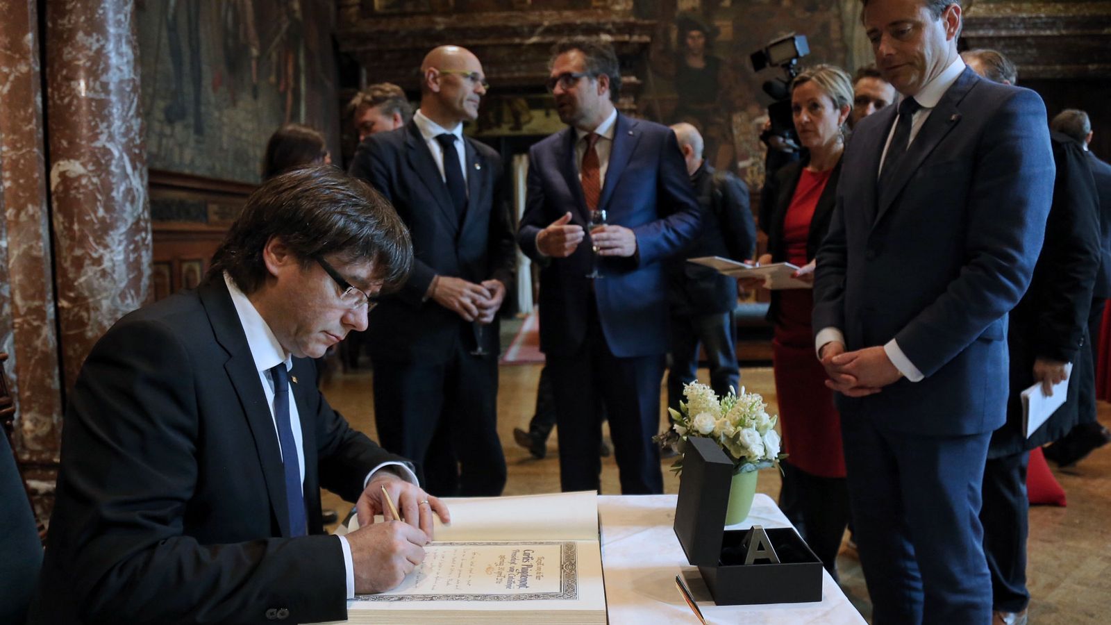 Foto: El presidente de la Generalitat, Carles Puigdemont (i), durante la firma del libro de oro del Ayuntamiento de Amberes. (EFE)