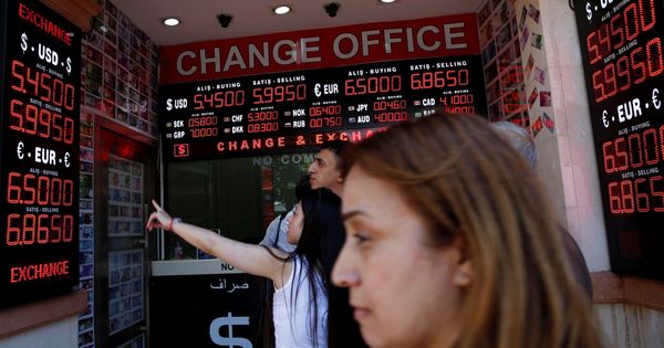 Foto: People check currency exchange rates at a currency exchange office in istanbul