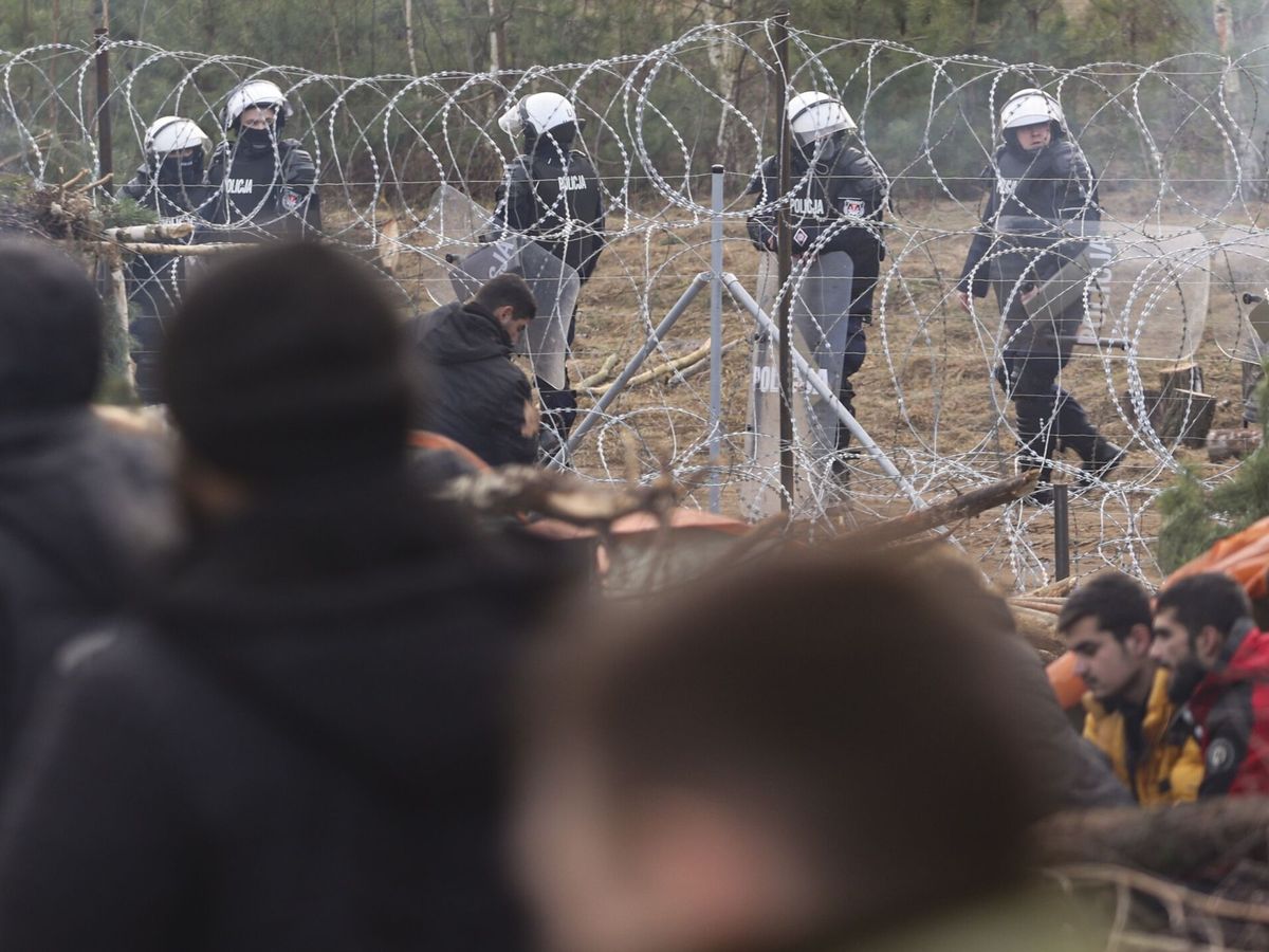 Foto: Soldados polacos observan desde su lado de la frontera a los refugiados y migrantes. (EFE/STRINGER) 
