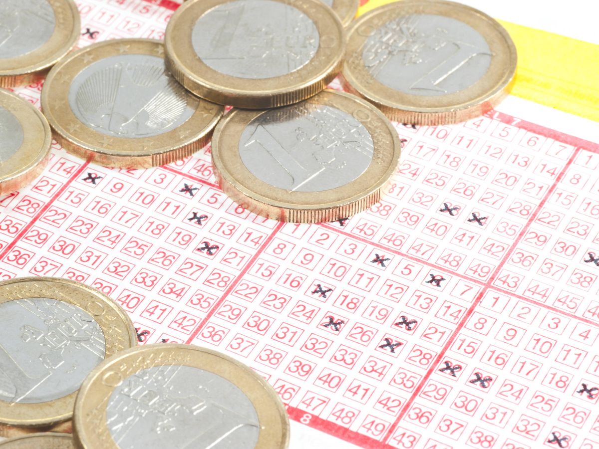 Foto: Un boleto de Euromillones, junto a varias monedas. (iStock)