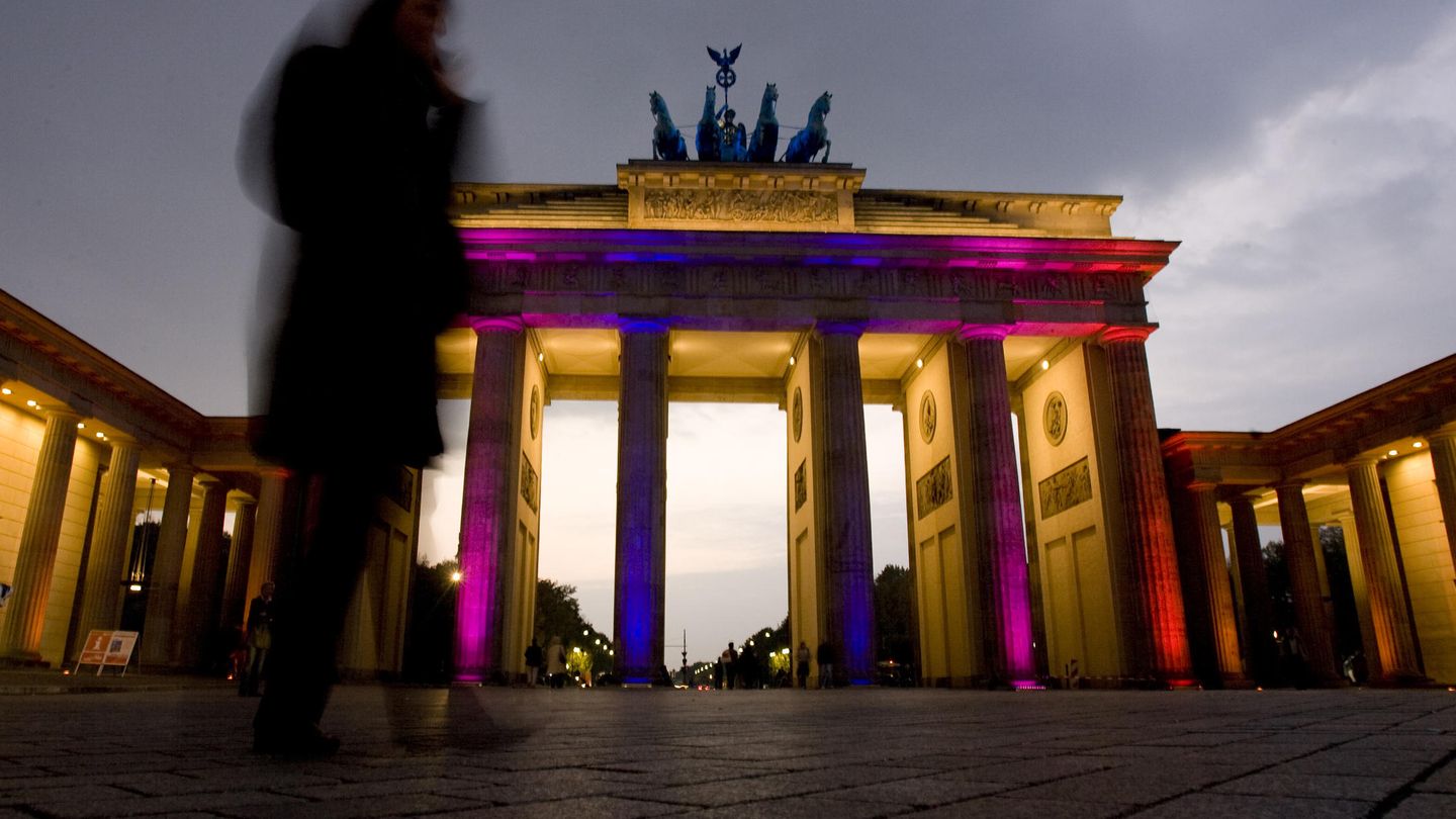 Una mujer pasa ante la puerta de Branderburgo iluminada durante el 'Festival de las luces' que Berlín celebra cada octubre (Reuters). 
