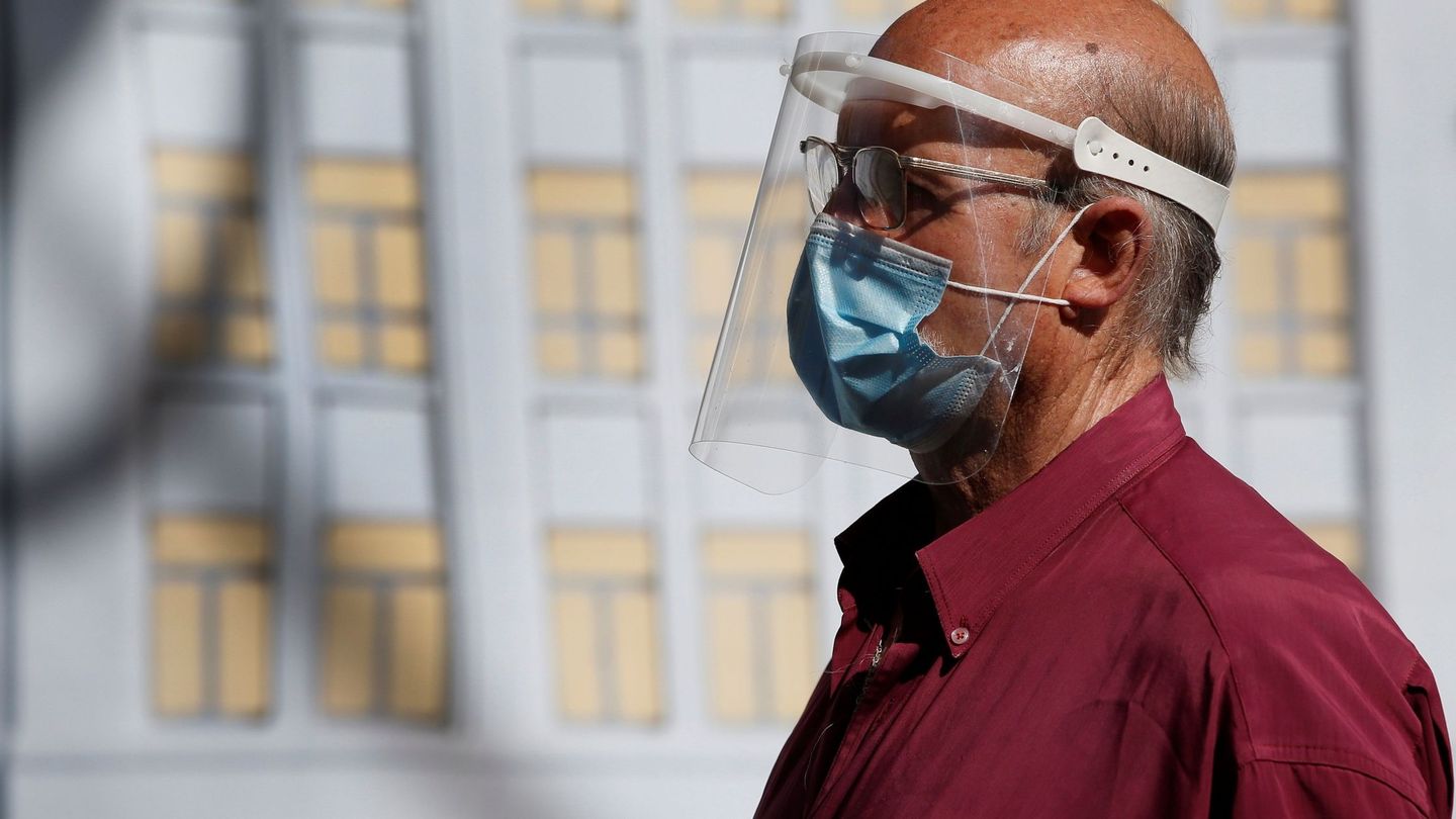 Un ciudadano lleva mascarilla y pantalla protectora mientras camina por el centro de Madrid. (EFE)