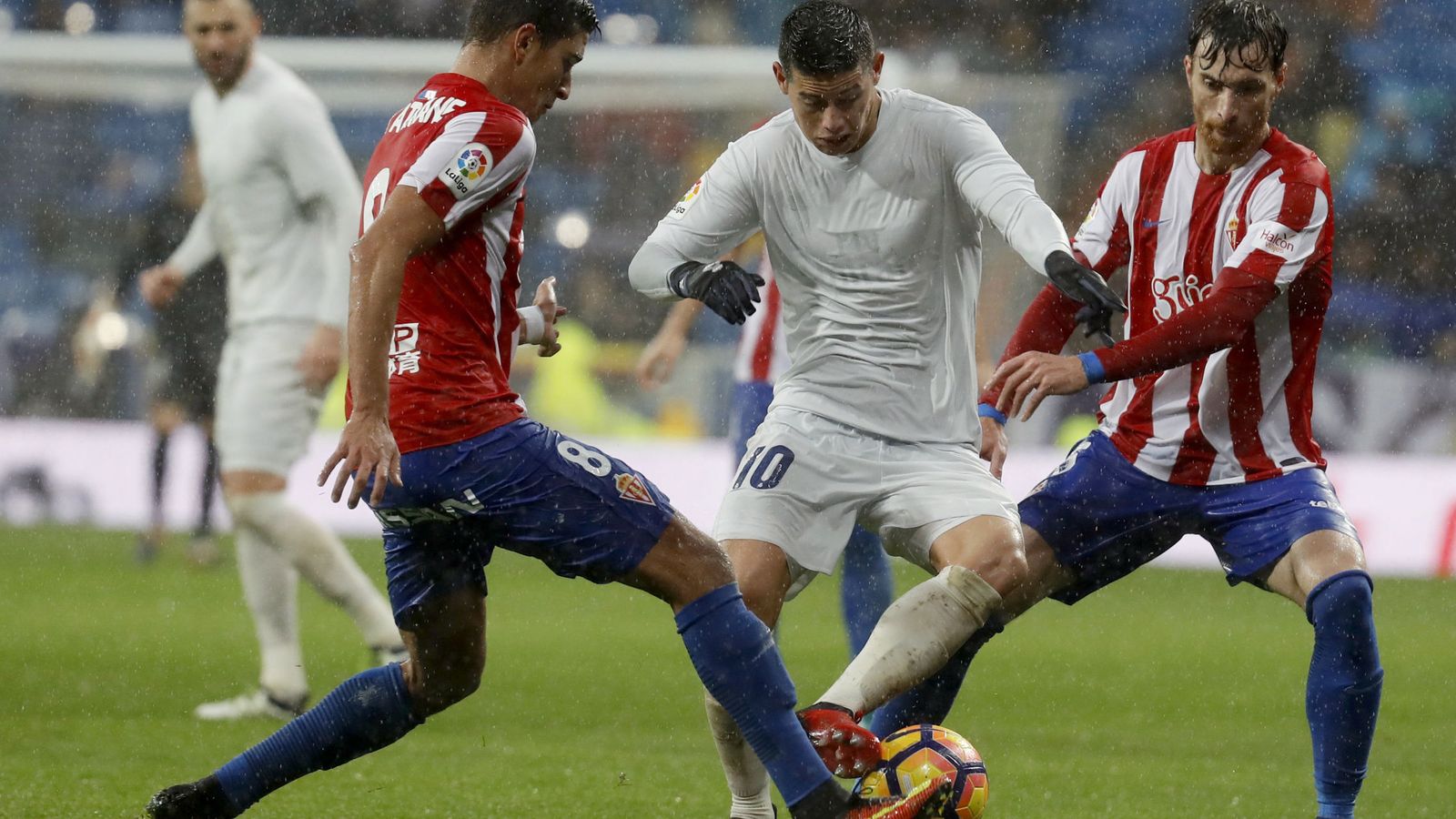 Foto: James Rodríguez, entre dos jugadores del Sporting, volvió a sellar un más que discreto partido (EFE)