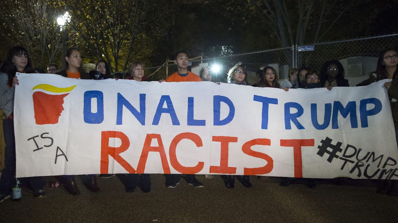 Foto: Unos inmigrantes sostienen una pancarta en la que se lee 'Donald Trump es un racista' frente a la Casa Blanca en Washington. (Efe) 