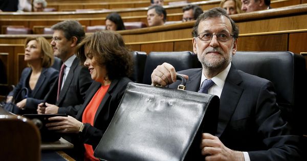 Foto: El presidente del Gobierno, Mariano Rajoy, sostiene su cartera en el Congreso de los Diputados. (EFE)