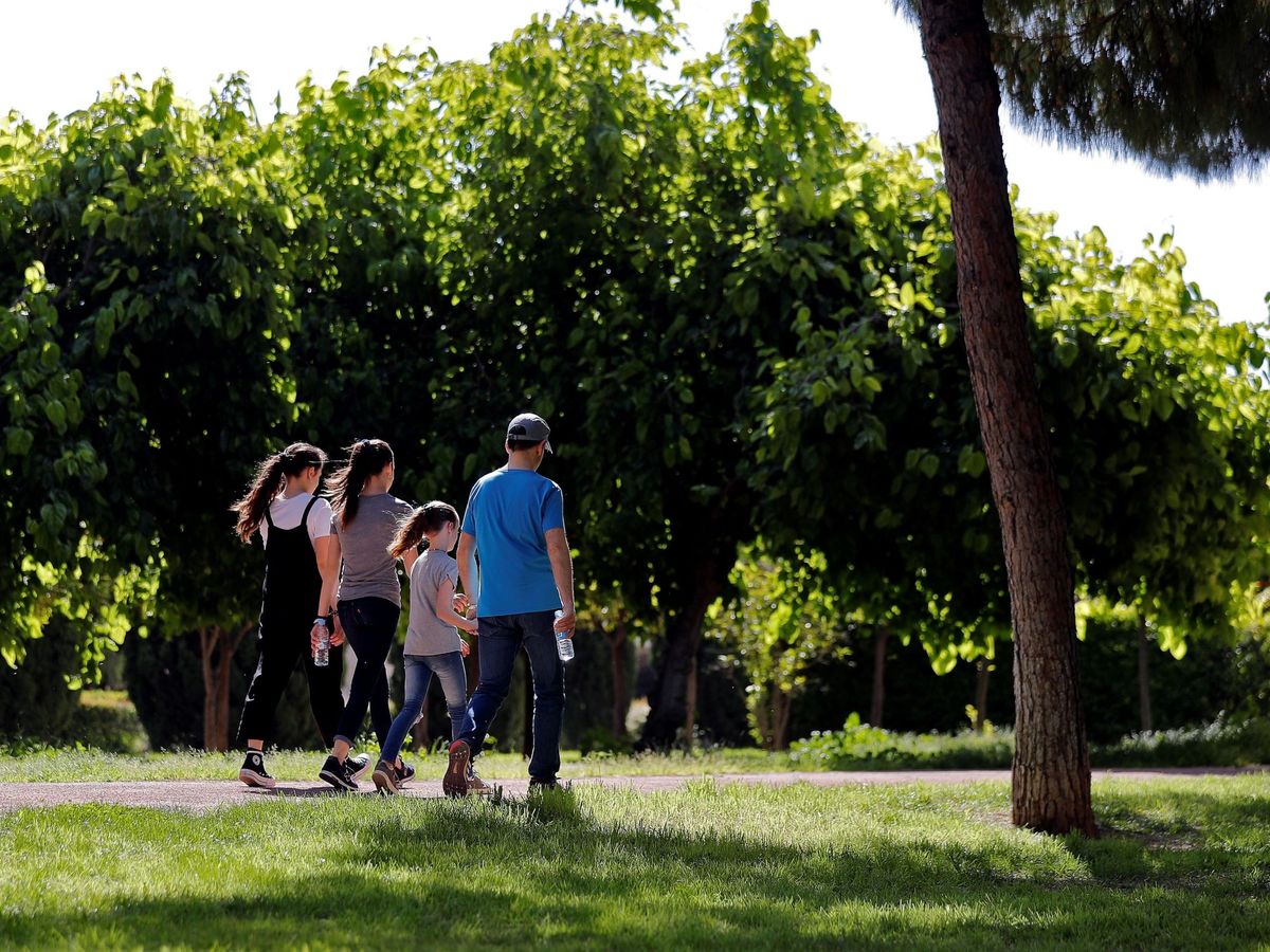 Foto: Una familia paseando por el jardín del Turia de Valencia. (EFE/Manuel Bruque)