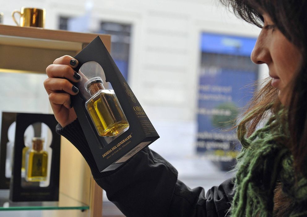 Foto: Una turista observa una botella de aceite de los olivares centenarios de la Alhambra. (Efe)