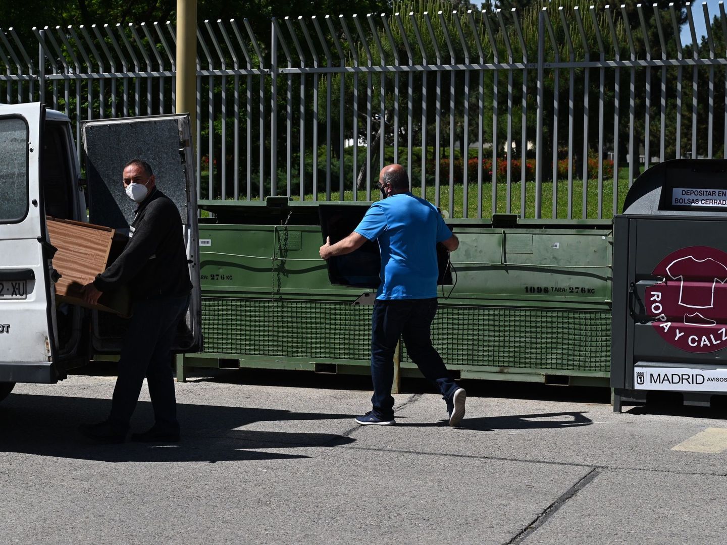 Varias personas reciclan en el punto limpio fijo de Arganzuela. (EFE/Fernando Villar)