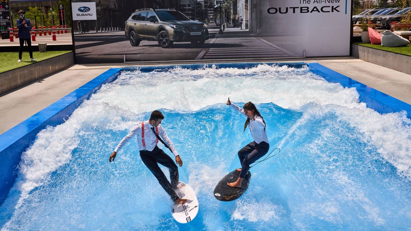 Los surfistas Garazi Sánchez y Andy Criere cogiendo olas en plena capital en la presentación del nuevo Outback. (Cortesía)
