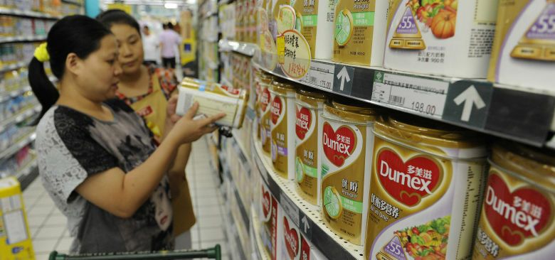 Una mujer china compra leche en polvo de la marca local de Danone en un supermercado en Pekín (Reuters).