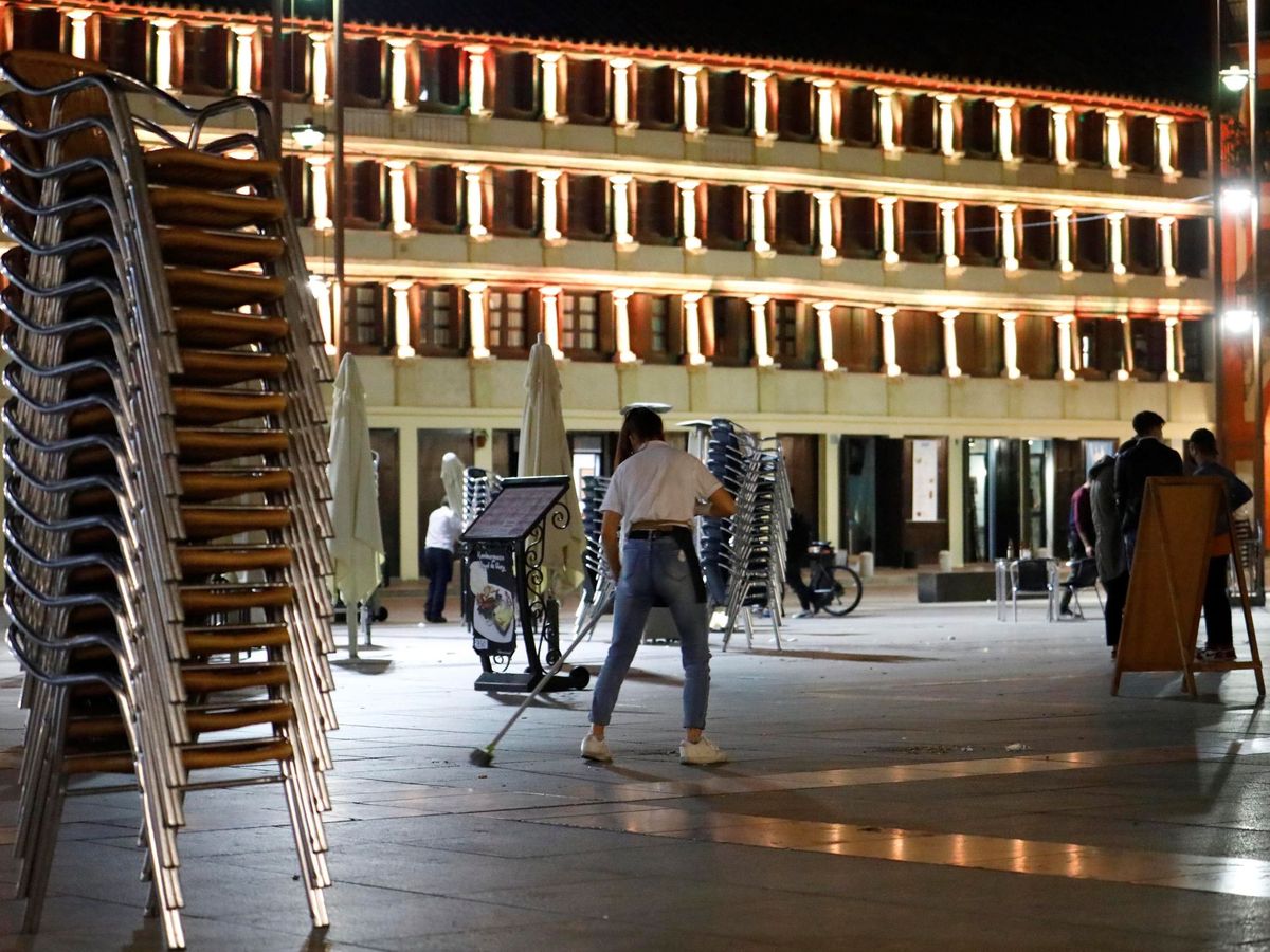 Foto: Un camarero recoge la terraza de su bar en Córdoba. (EFE)