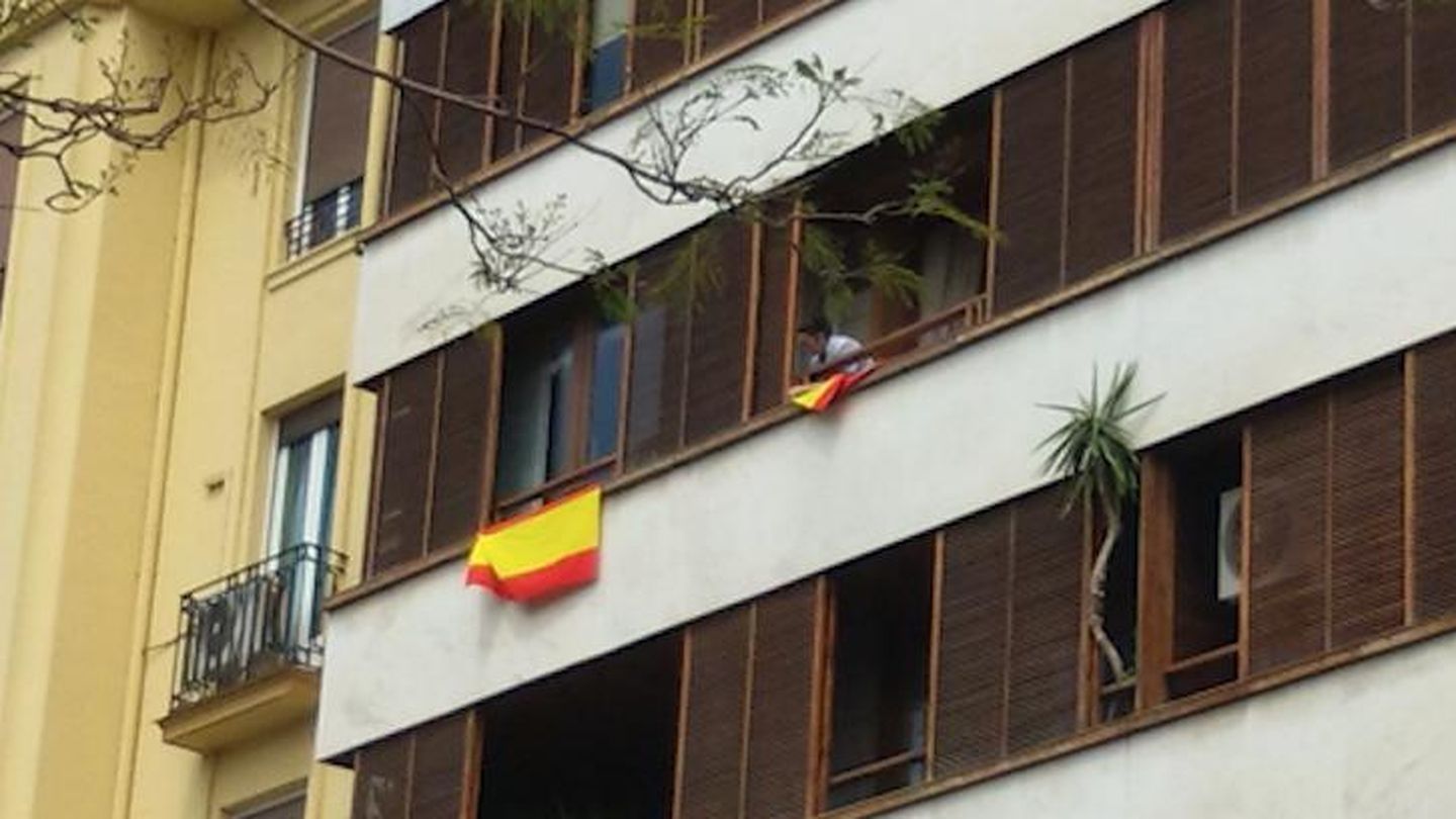 Momento en el que la empleada del hogar de Barberá ha amarrado las banderas por el viento. (EC)
