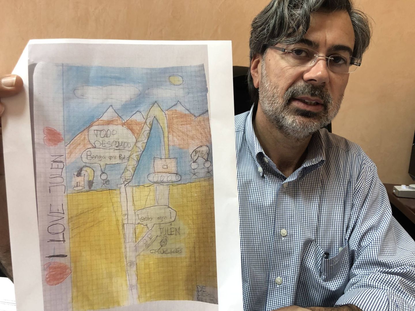 El alcalde de Totalán, Miguel Ángel Escaño, enseña un dibujo solidario de un niño sobre el rescate. (A. R.)