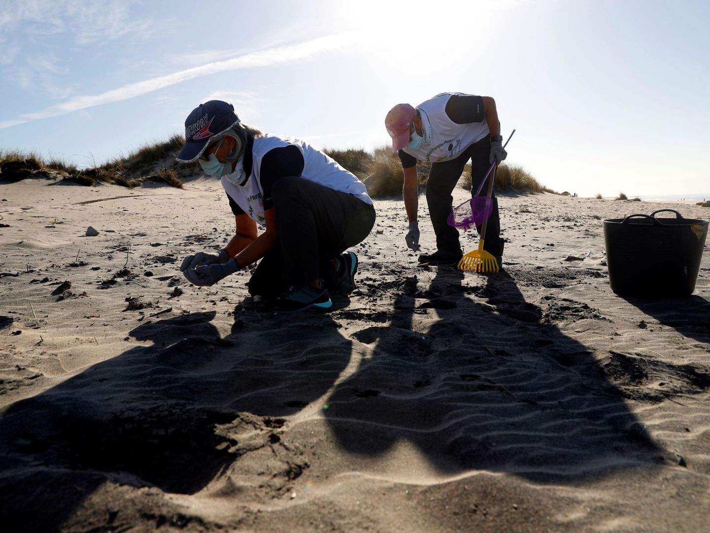 Voluntarios recogen basura en una playa cercana a Matalascañas. (EFE)