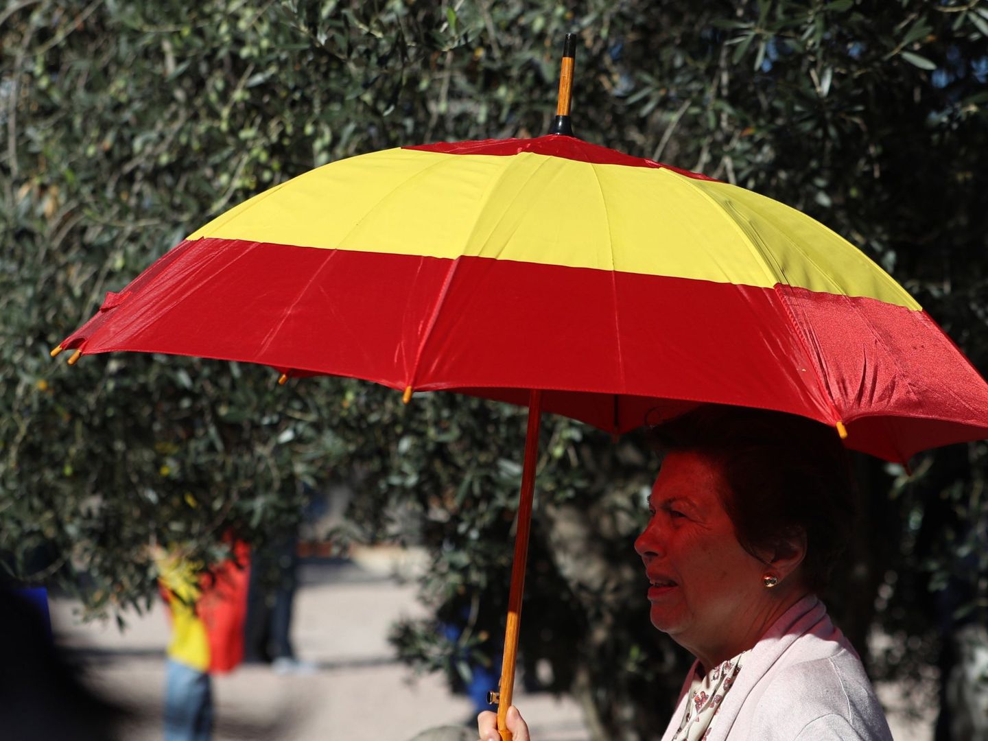 Una mujer, con un paraguas de la bandera de España. (EFE)