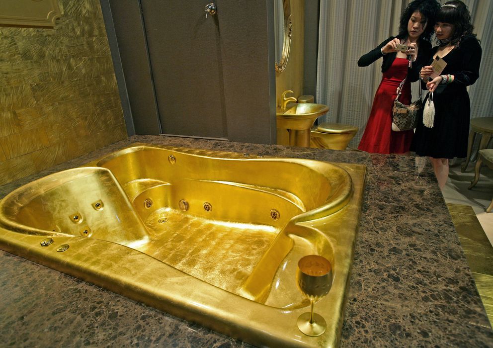 Foto: Dos visitantes toman fotografías de una bañera de oro en la Feria de Millonarios de Shangái, China (Reuters). 