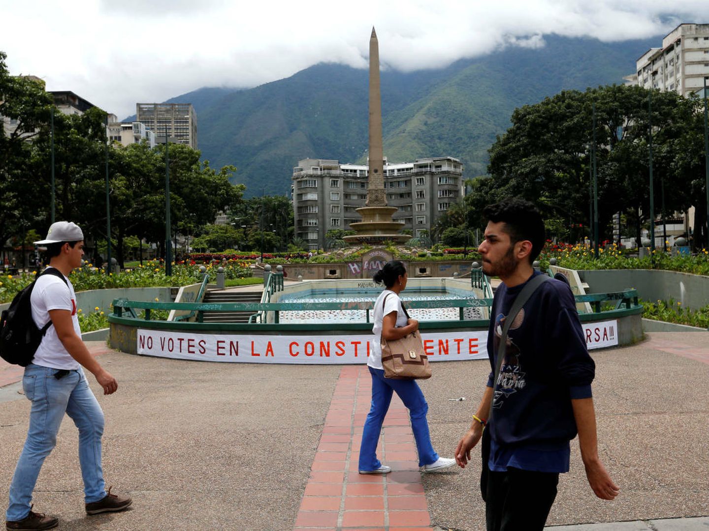 Habitantes de Caracas pasan por delante de una pancarta llamando al boicot electoral, el 26 de julio de 2017. (Reuters)