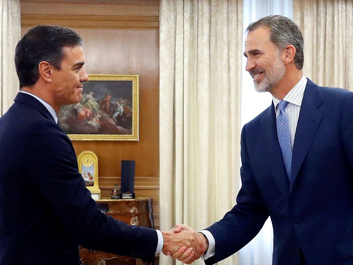 Pedro Sánchez y el rey Felipe se dan afectuosamente la mano. (EFE)