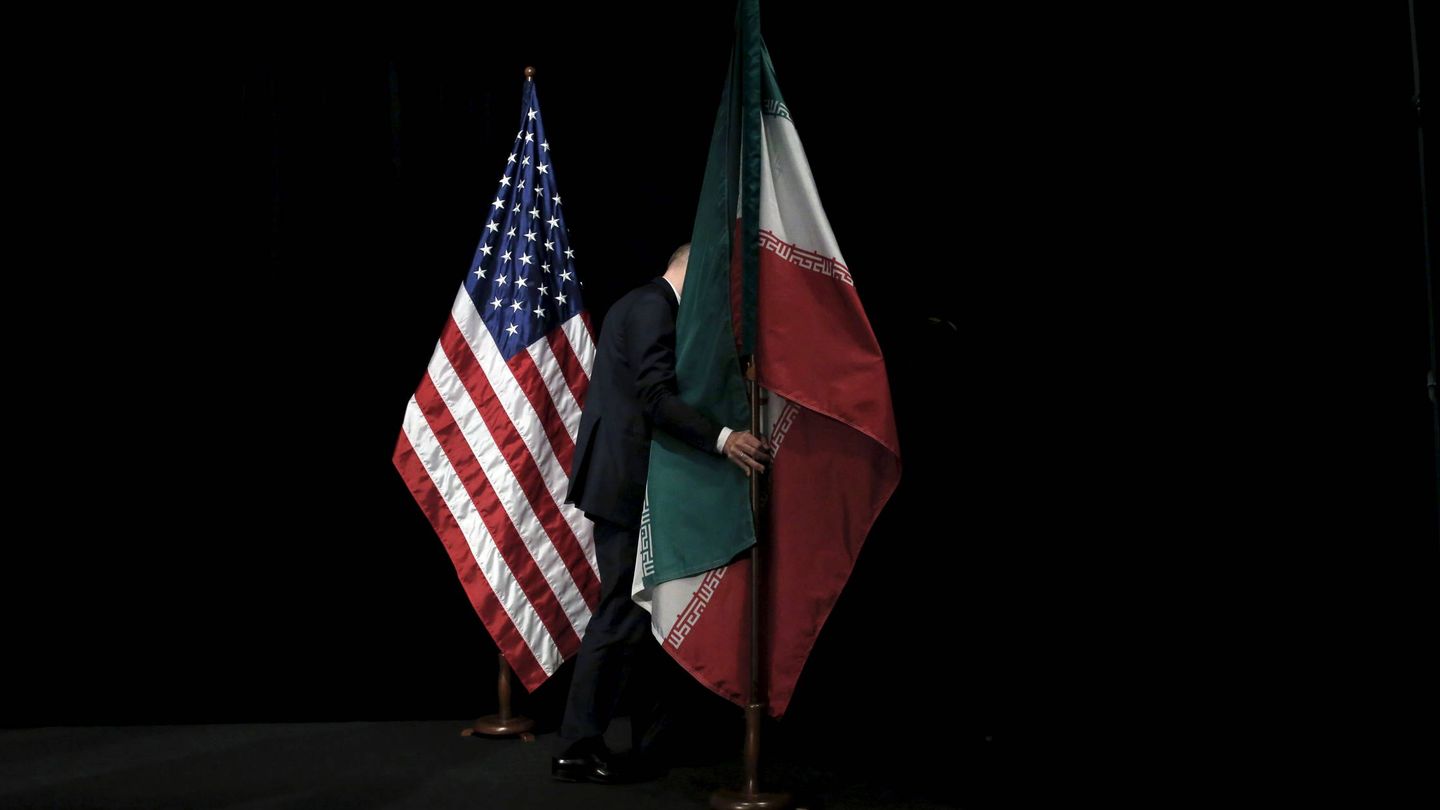 Un trabajador retira una bandera de Irán tras una cumbre sobre el acuerdo nuclear, en Viena, el 14 de julio de 2015. (Reuters) 