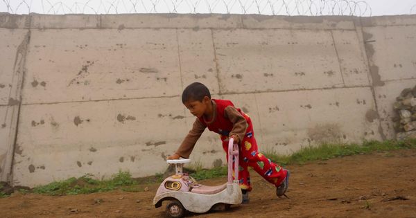 Foto: Un niño de una barriada juega junto a un muro del opulento barrio de Las Casuarinas, en Lima. (EFE)
