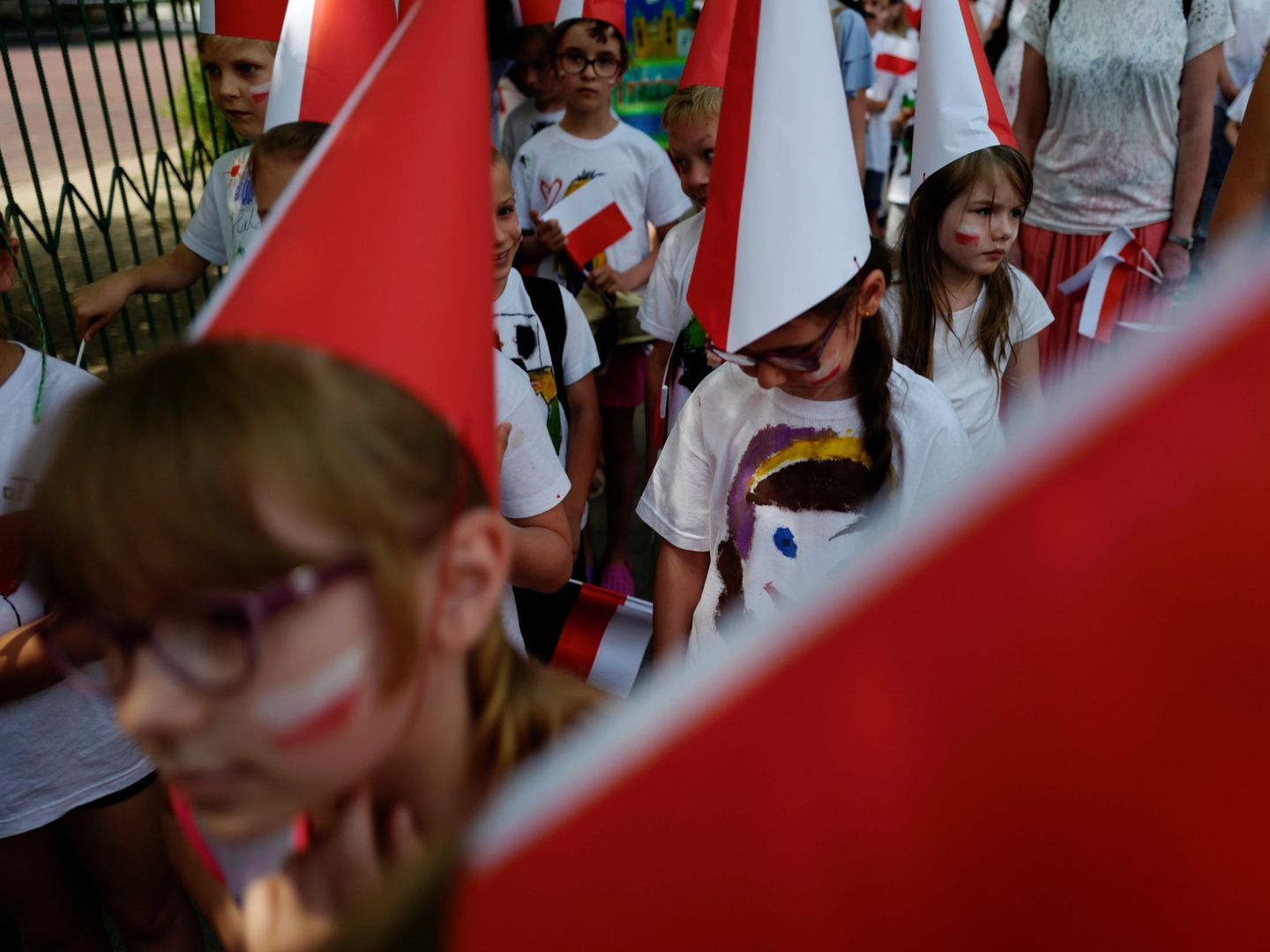 Alumnos con capirotes, banderas y la cara pintada con los colores de Polonia (REUTERS)